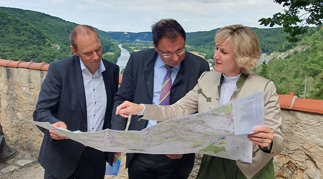 Kartenvorstellung auf Burg Prunn im Altmühltal  Drei Personen schauen auf eine Karte