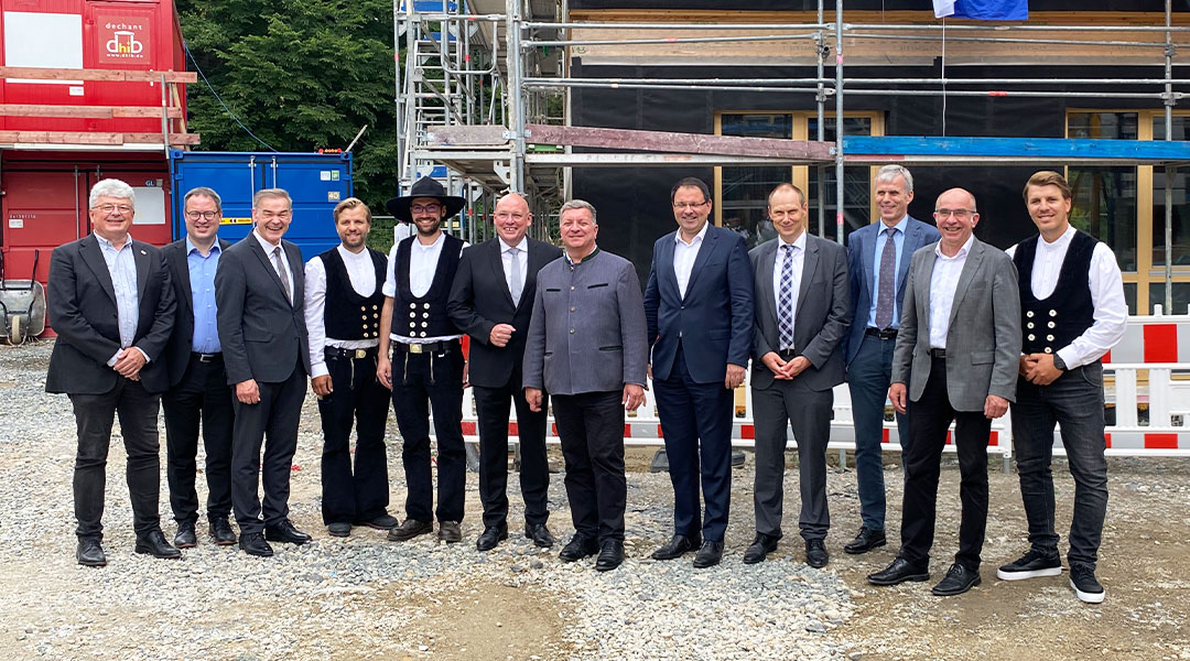 Richtfest Markredwitz Zwölf Personen stehen für ein Gruppenbild von links nach rechts aufgereiht beim Richtfest in Marktredwitz.