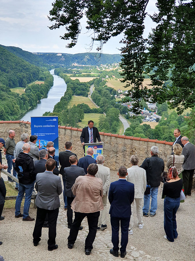 Kartenvorstellung auf Burg Prunn im Altmühltal Ausblick von der Burg. Im Vordergrund steht eine Gruppe von Menschen, die einer Person zuhören